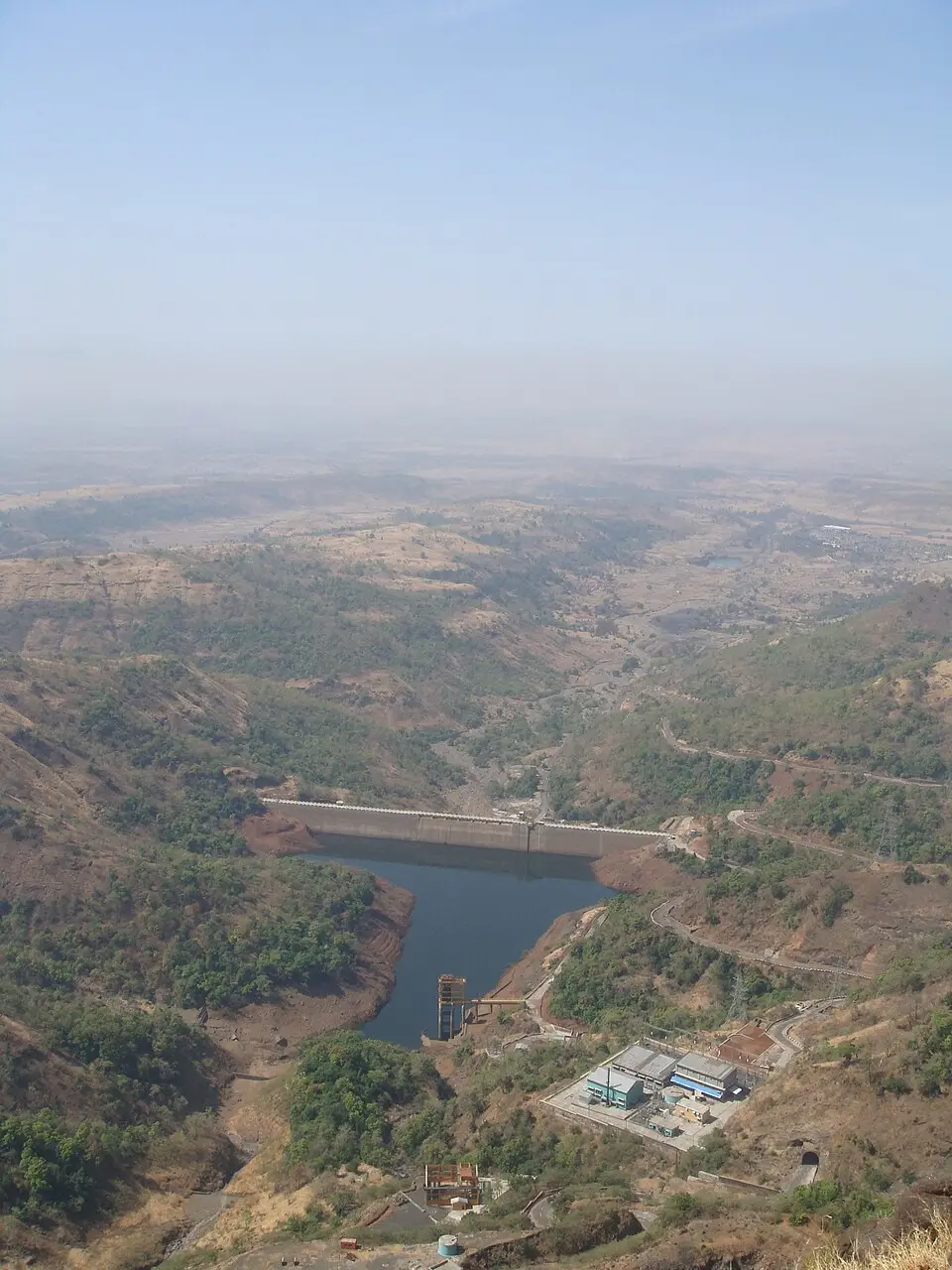 Concrete wall of Ghatghar dam among green Sahyadri hills